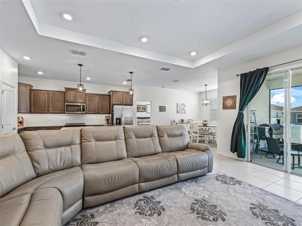 a living room with furniture and a view of kitchen