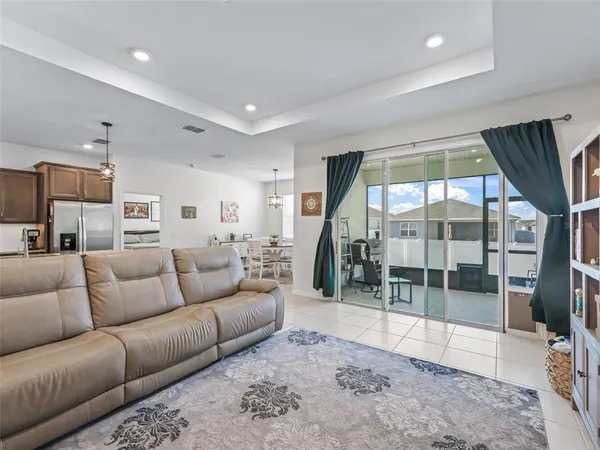 a living room with furniture a large window and a wooden floor