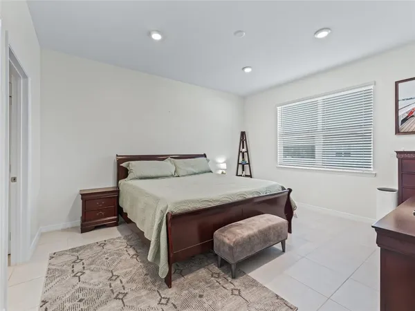 a bedroom with a bed mirror and a window