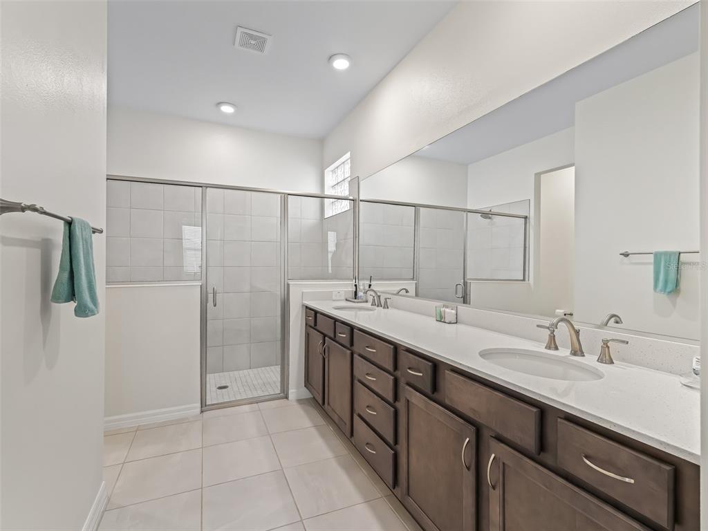 7206 Southwest 60th Lane Ocala, FL 34474 - Photo 23 of 50 a spacious bathroom with a double vanity sink a mirror and shower