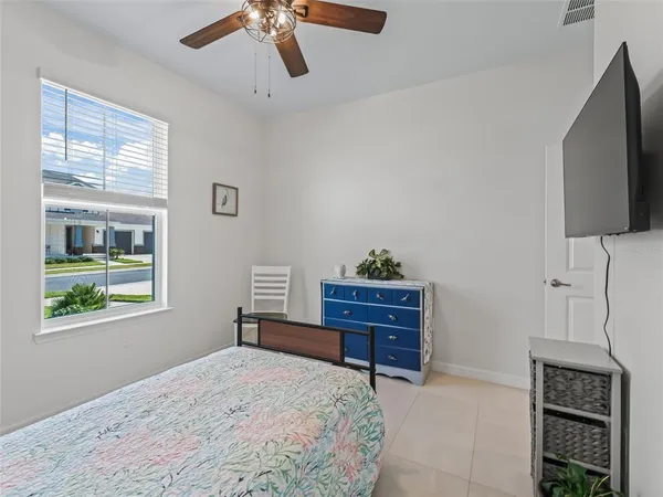 a bedroom with a bed dresser and a flat tv screen