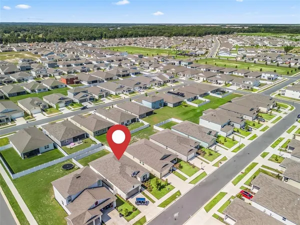 an aerial view of residential houses with outdoor space and swimming pool