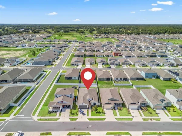 an aerial view of a house with a yard and potted plants
