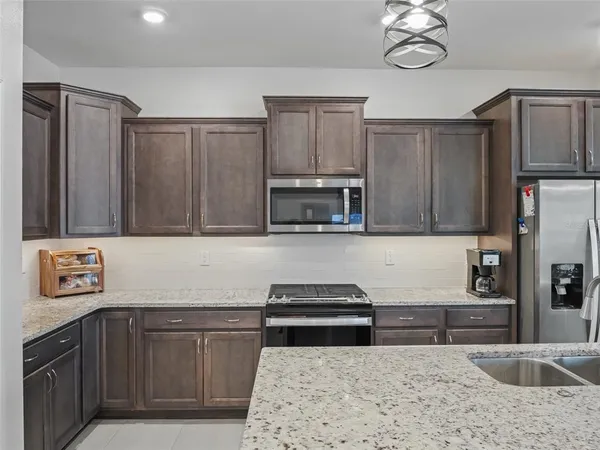 a kitchen with stainless steel appliances granite countertop a sink stove and refrigerator