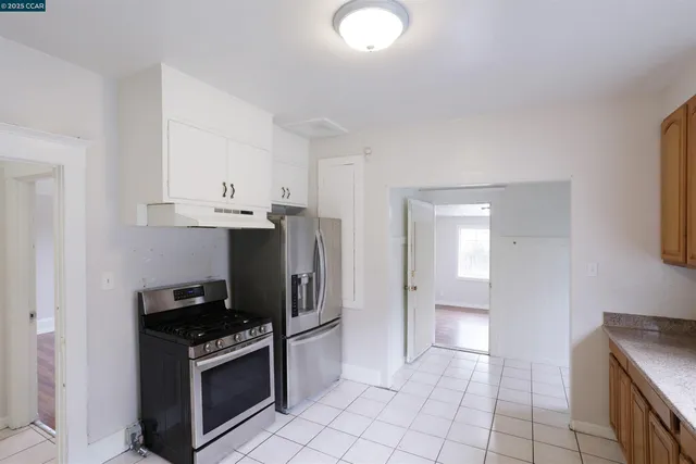 a kitchen with granite countertop a stove top oven and cabinets