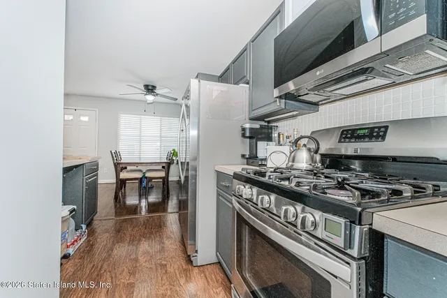 a kitchen with a stove and a wooden floor