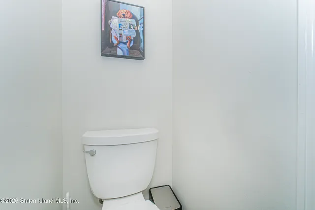 a white toilet sitting next to a white wall