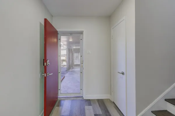 a view of a hallway with wooden floor and entryway