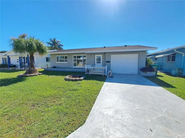 a view of a house with a backyard and a patio