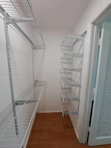a view of walk in closet with empty racks