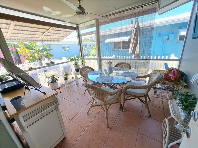 a dining room with furniture and a floor to ceiling window