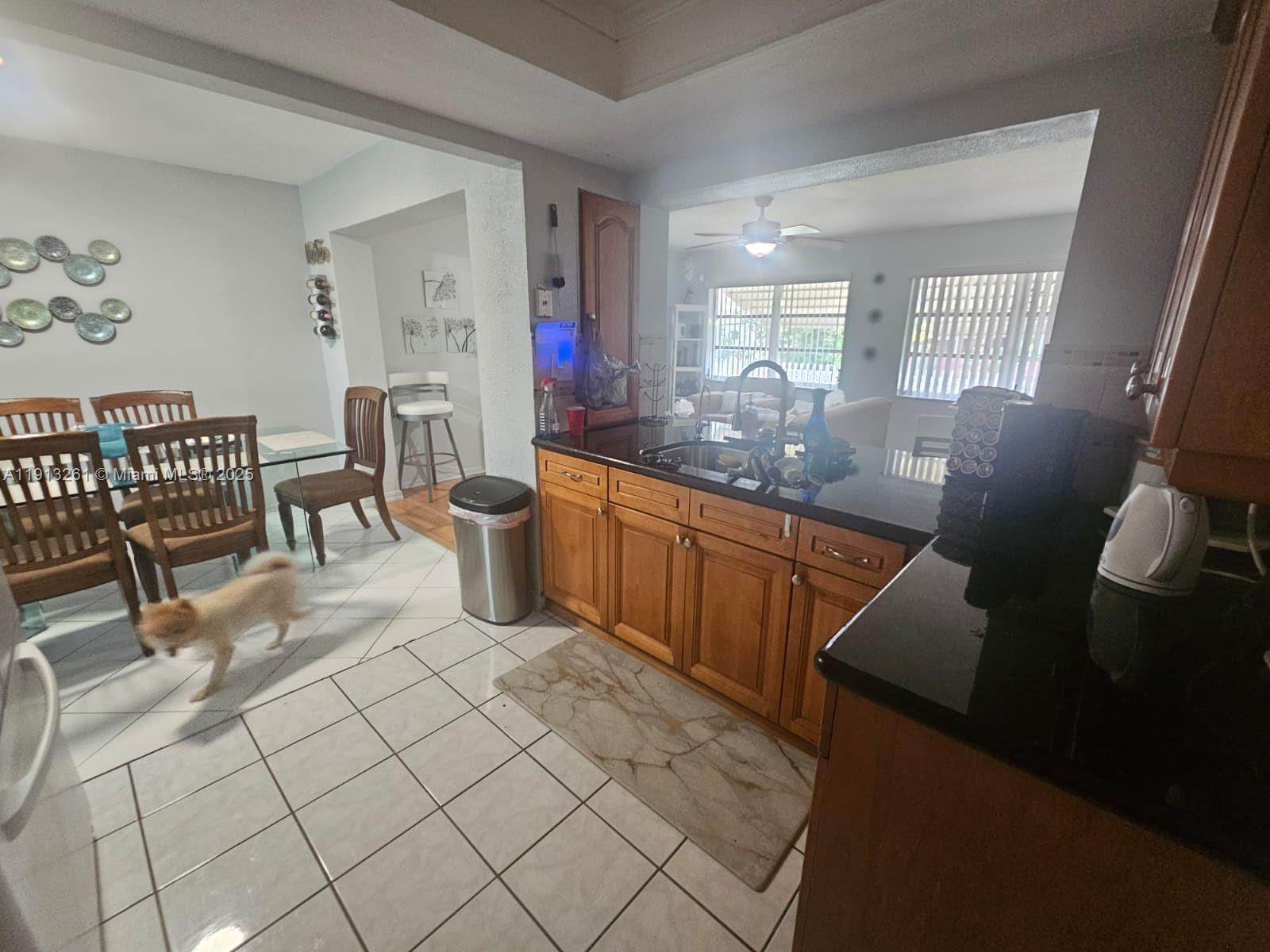 5010 Northwest 51st Court Tamarac, FL 33319 - Photo 5 of 16 a kitchen with a sink and chairs