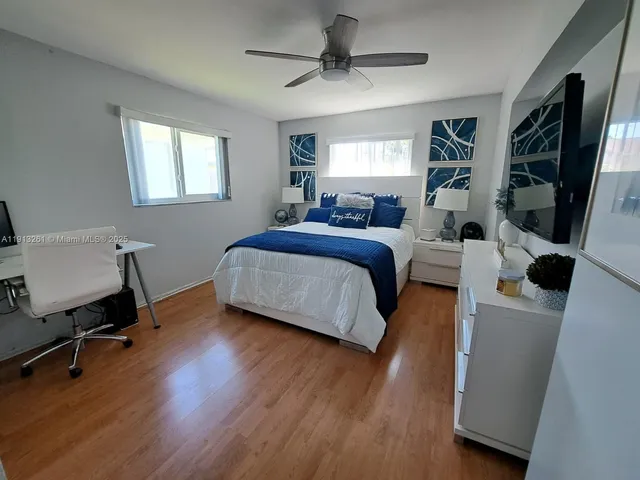 a bedroom with a bed a flat screen tv and a window