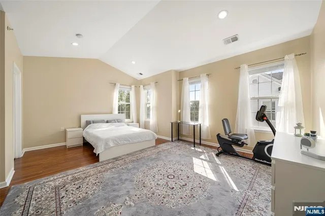 a spacious bedroom with a bed a couch and large window