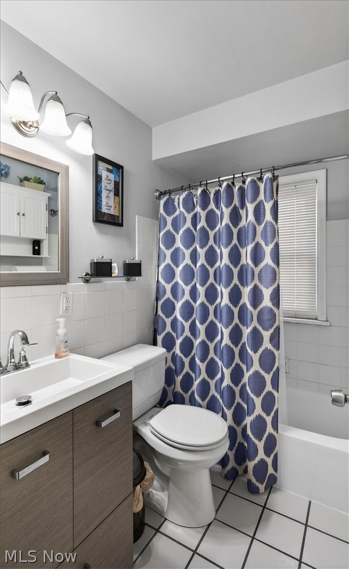 17282 McCracken Road Maple Heights, OH 44137 - Photo 10 of 26 Full bath featuring vanity, shower / bathtub combination, light tile patterned flooring, and tile walls