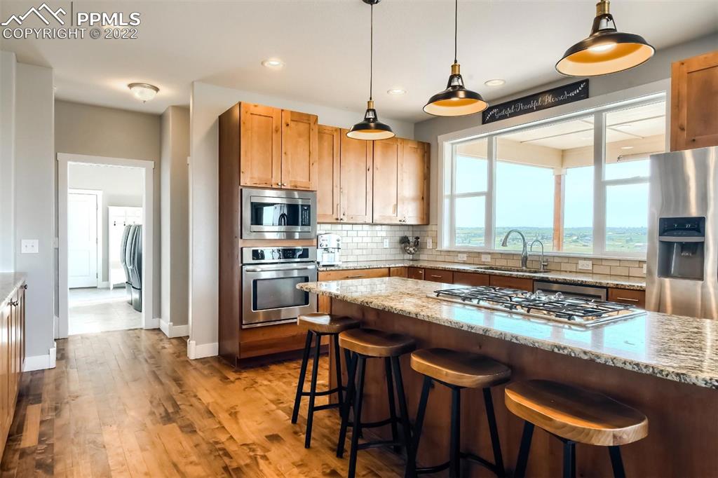 34698 Southern Cross Loop Kiowa, CO 80117 - Photo 12 of 50 a kitchen with a stove a sink and a wooden floor