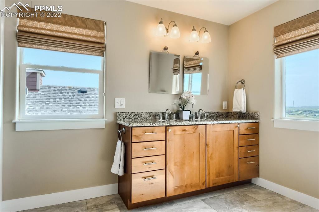 34698 Southern Cross Loop Kiowa, CO 80117 - Photo 21 of 50 a bathroom with a granite countertop sink and a mirror
