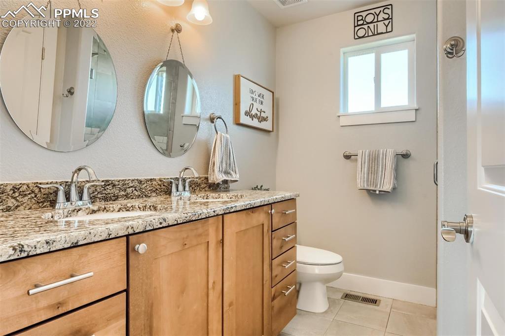 34698 Southern Cross Loop Kiowa, CO 80117 - Photo 28 of 50 a bathroom with a granite countertop toilet sink and mirror
