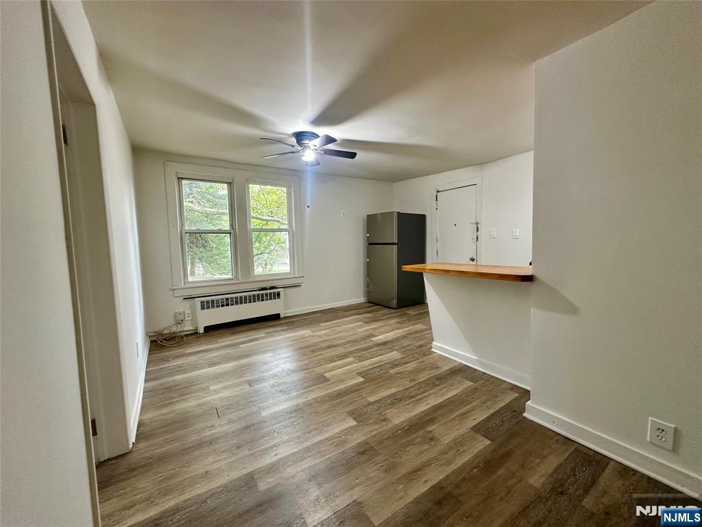 390 Orange Road Montclair, NJ 07042 - Photo 5 of 16 an empty room with wooden floor and windows