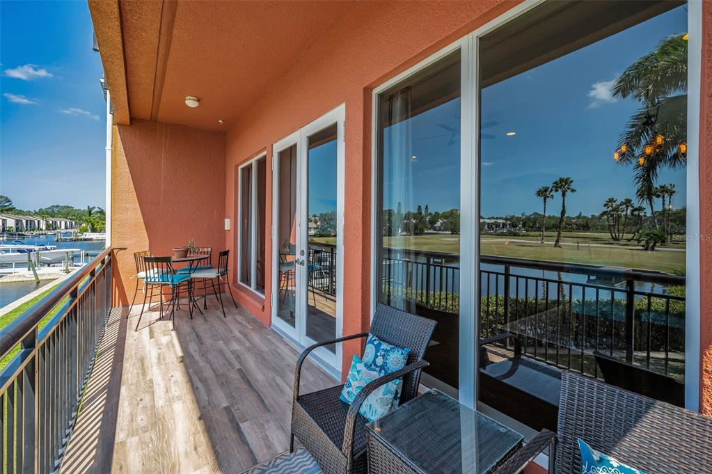 47 West Morgan Street Tarpon Springs, FL 34689 - Photo 25 of 64 a balcony with chairs and wooden floor