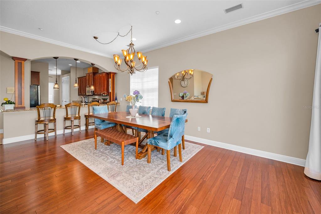 47 West Morgan Street Tarpon Springs, FL 34689 - Photo 26 of 64 a dining room with wooden floor a chandelier a wooden table and chairs