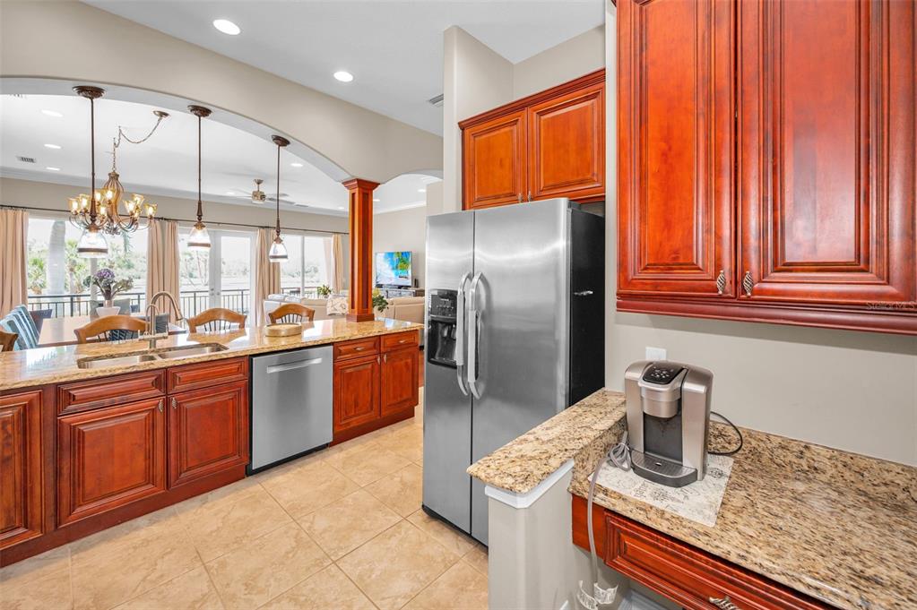 47 West Morgan Street Tarpon Springs, FL 34689 - Photo 4 of 64 a kitchen with stainless steel appliances granite countertop a refrigerator a stove and a sink with wooden cabinets