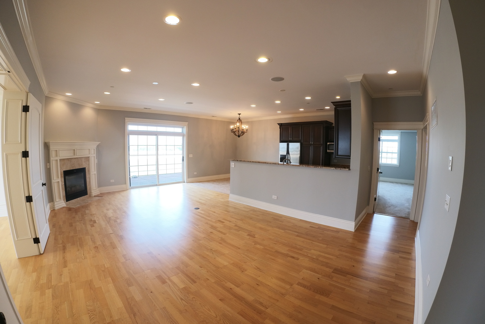 10765 Clock Tower Drive, Unit 602 Countryside, IL 60525 - Photo 4 of 21 a view of a kitchen and an empty room with wooden floor and a window