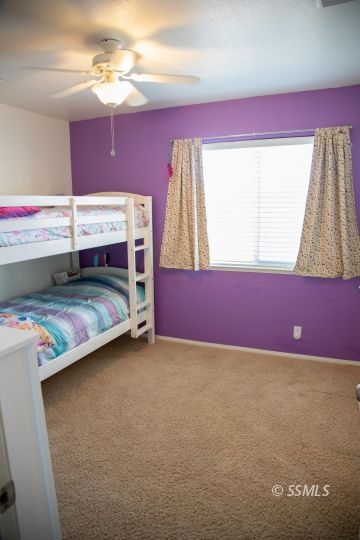 1017 Porter Street Ridgecrest, CA 93555 - Photo 9 of 15 a bedroom with a bed and a chandelier