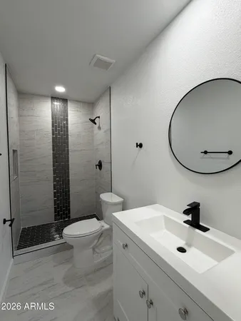 a bathroom with a sink a toilet and shower