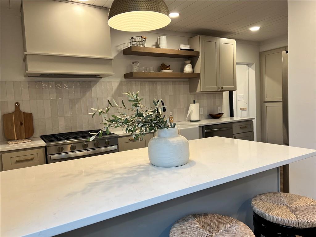 1006 Edgewood Road New Kensington, PA 15068 - Photo 8 of 47 a kitchen with stainless steel appliances a table chairs in it and wooden floors