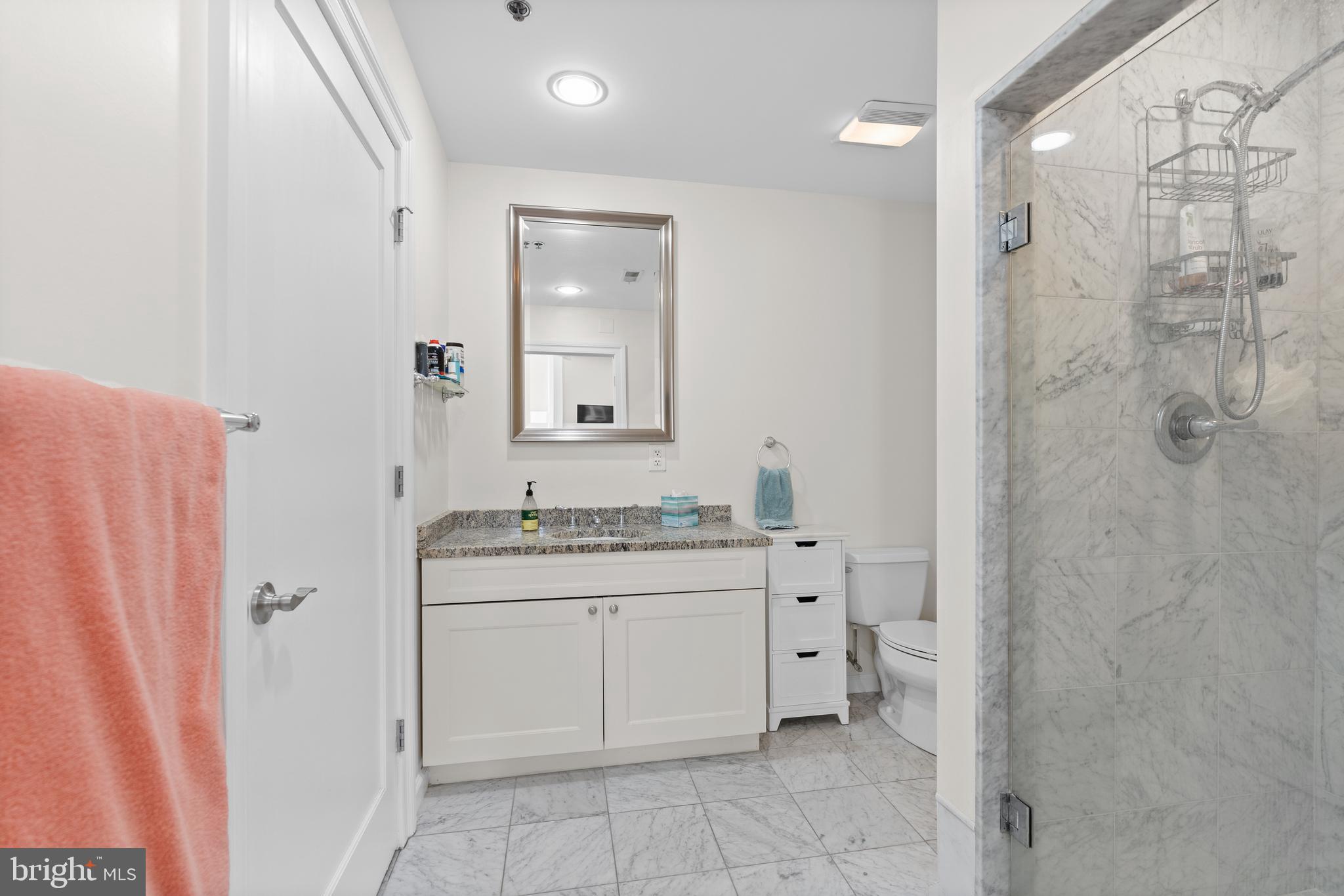 1811 Chestnut Street, Unit 501 Philadelphia, PA 19103 - Photo 15 of 26 a bathroom with a granite countertop sink toilet and shower