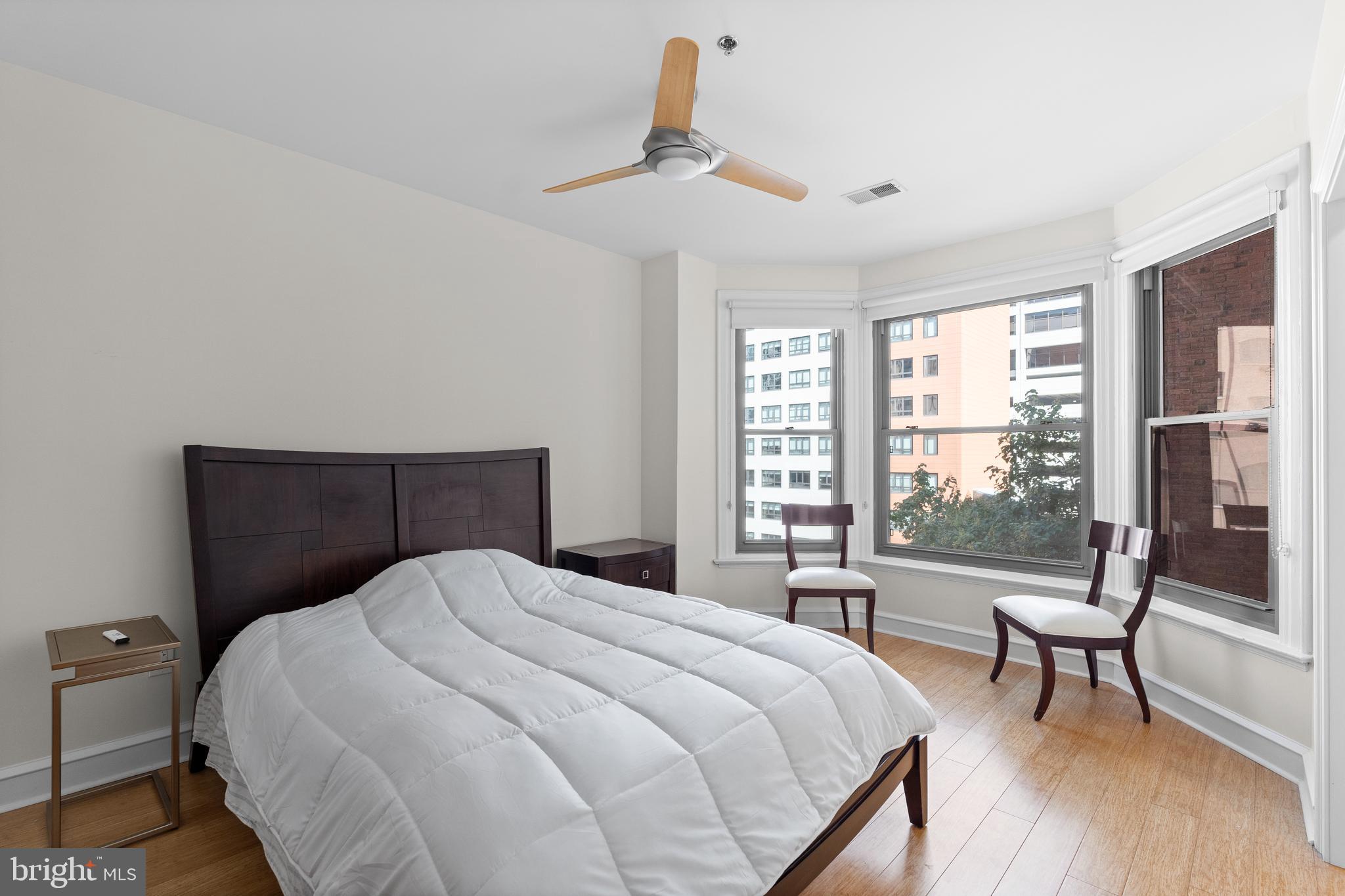 1811 Chestnut Street, Unit 501 Philadelphia, PA 19103 - Photo 19 of 26 a bedroom with a bed a chair and a large window