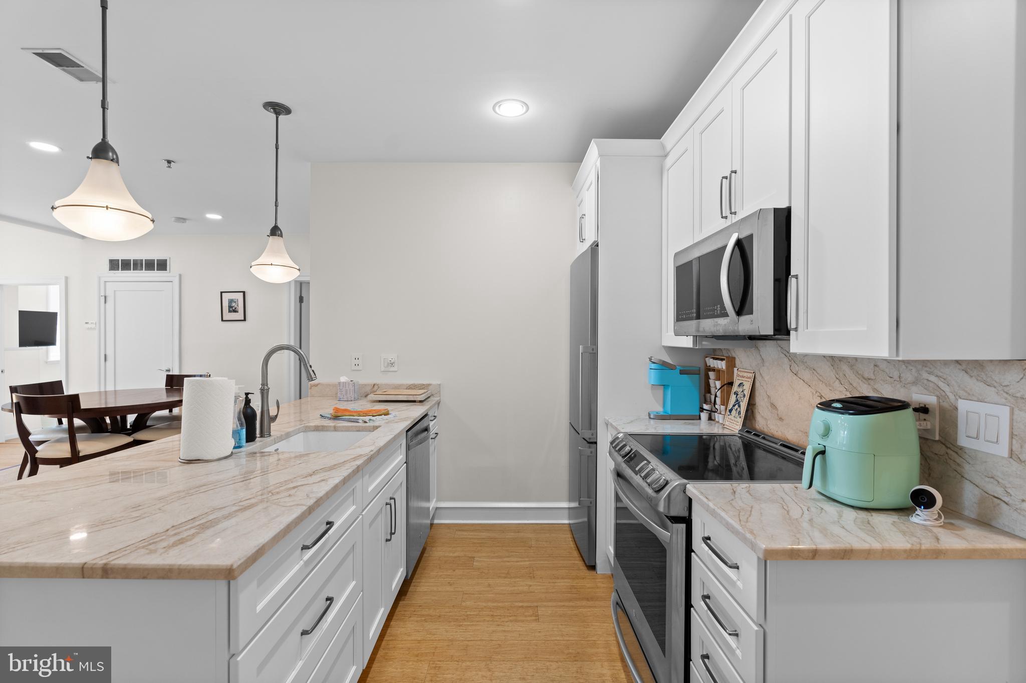 1811 Chestnut Street, Unit 501 Philadelphia, PA 19103 - Photo 2 of 26 a kitchen with kitchen island granite countertop a sink a stove top oven a counter space and cabinets