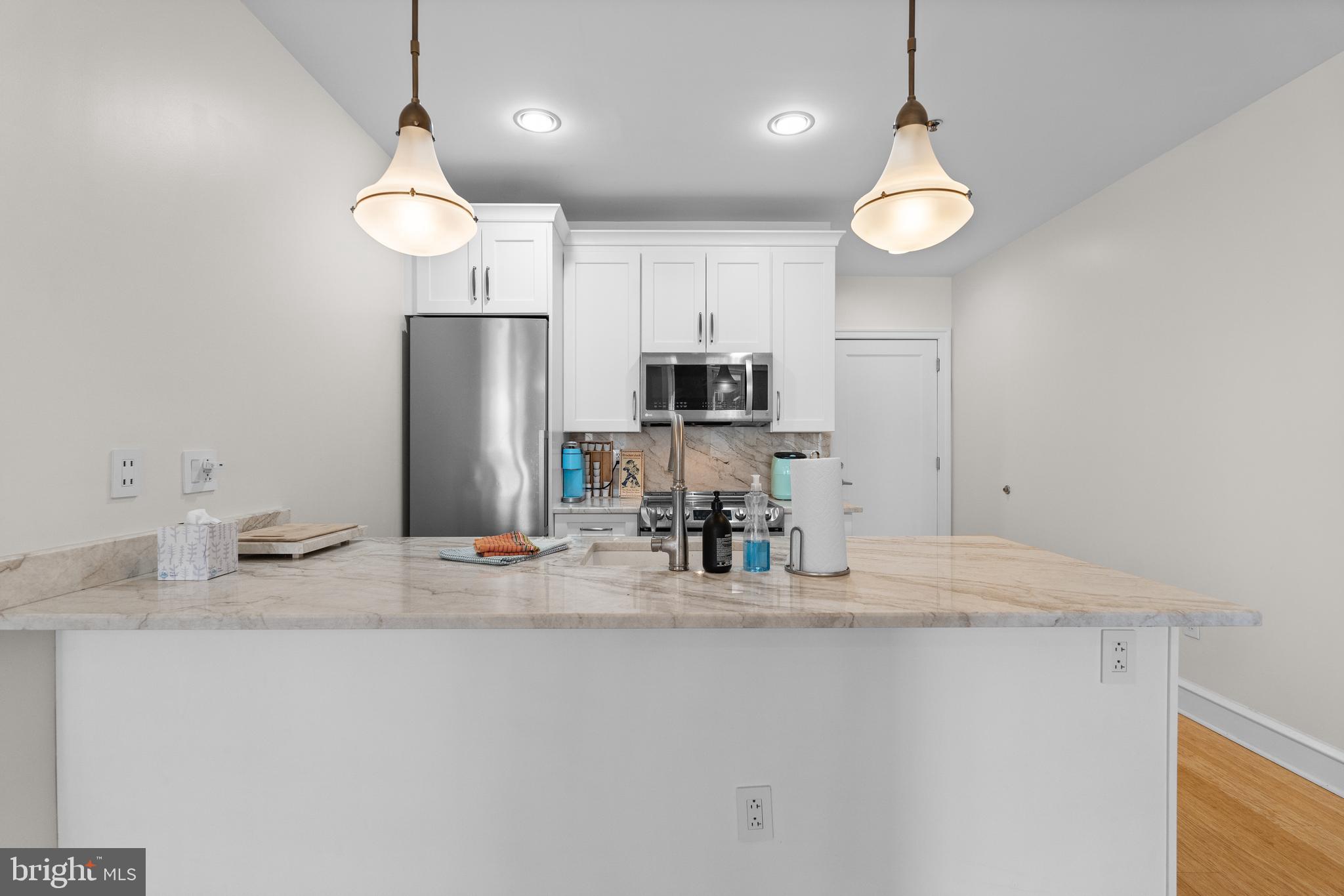 1811 Chestnut Street, Unit 501 Philadelphia, PA 19103 - Photo 9 of 26 a kitchen with stainless steel appliances granite countertop a sink refrigerator stove and microwave