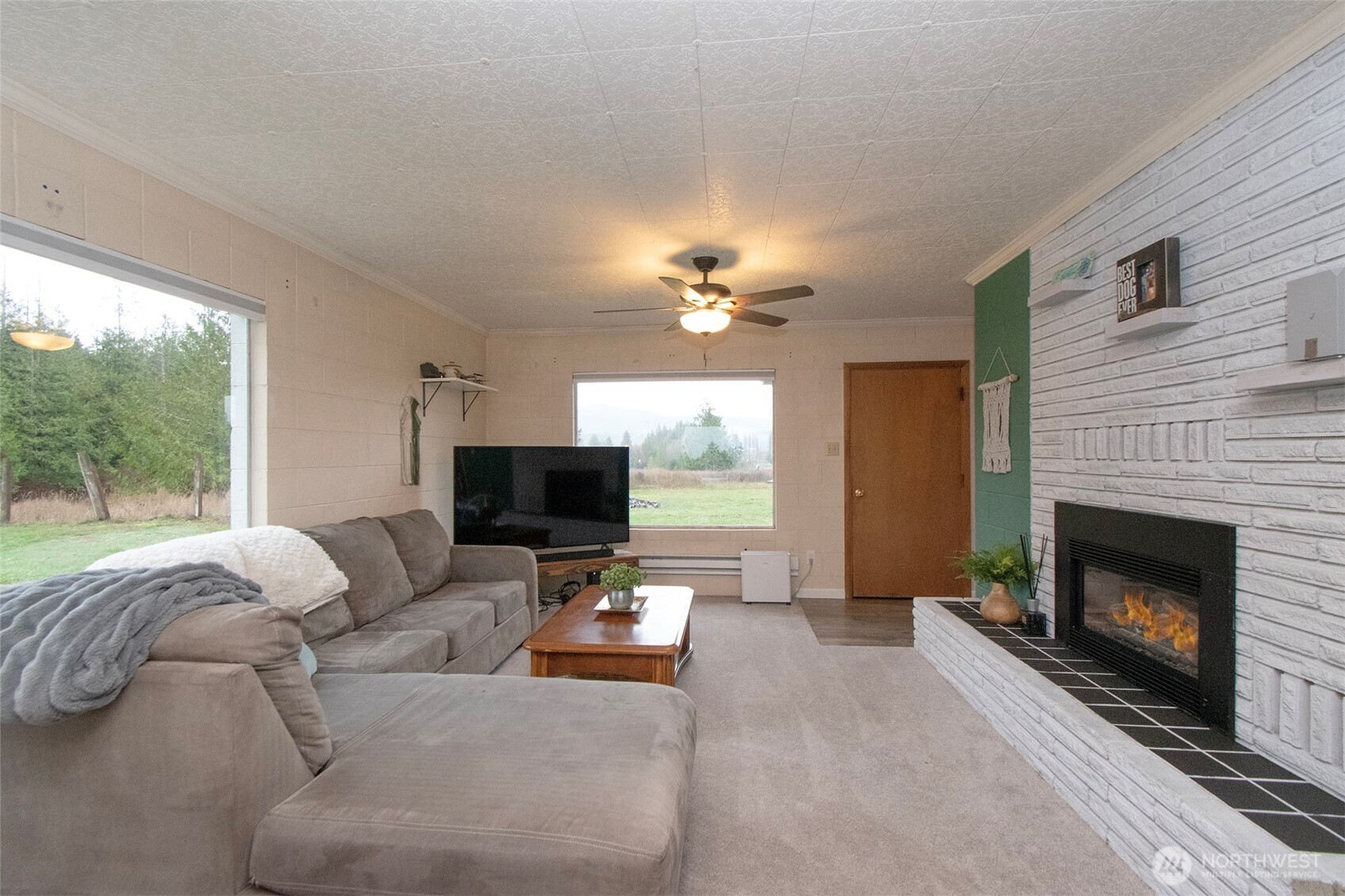 163 Cliff Robinson Lane Sequim, WA 98382 - Photo 6 of 40 a living room with furniture a fireplace and a flat screen tv