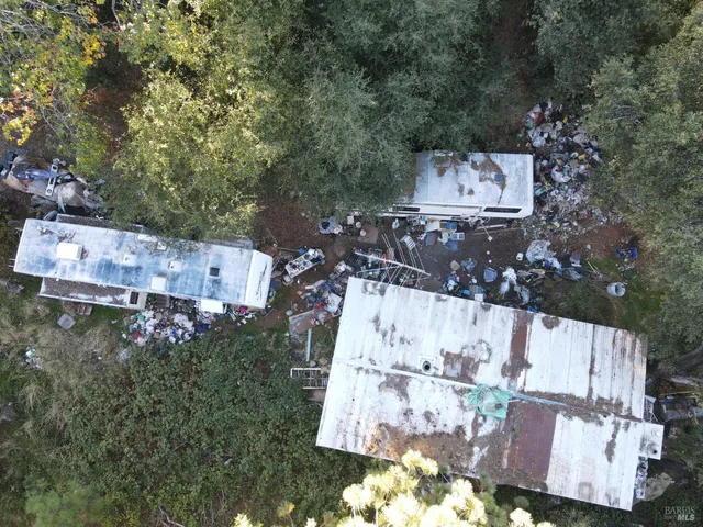 an aerial view of residential house with outdoor space and trees all around