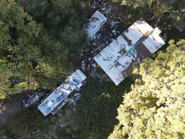 an aerial view of a house a yard and mountain
