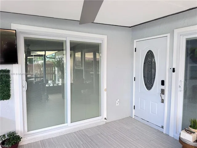 a view of a room with wooden floor and entryway