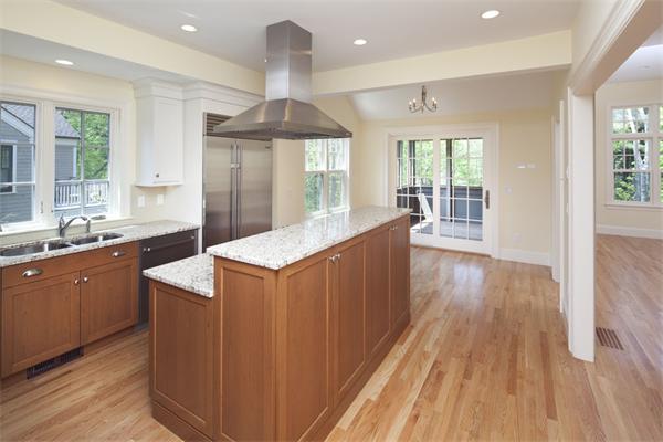 a large kitchen with wooden floors and stainless steel appliances