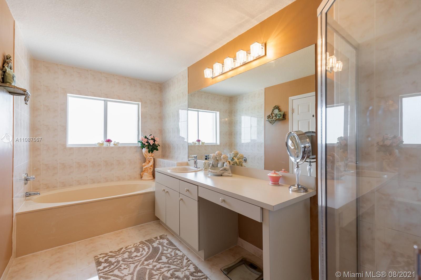 18017 Southwest 148th Ave Road Miami, FL 33187 - Photo 14 of 27 a bathroom with a tub sink and mirror