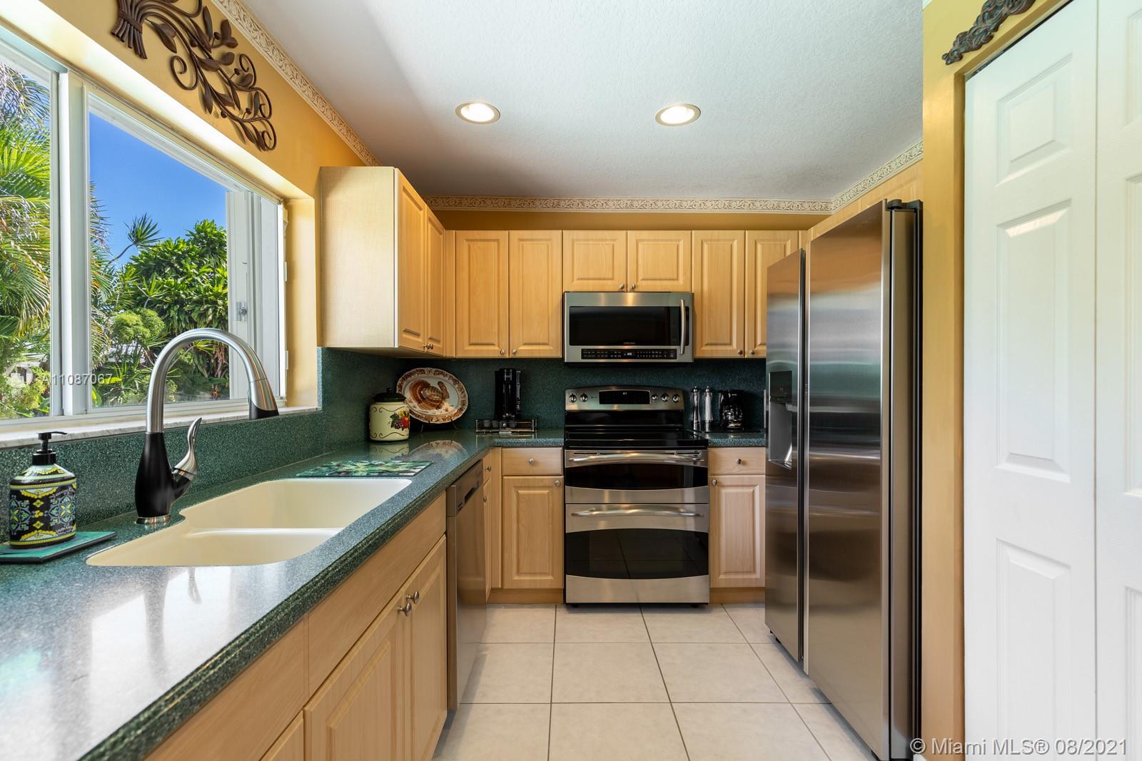 18017 Southwest 148th Ave Road Miami, FL 33187 - Photo 9 of 27 a kitchen with stainless steel appliances granite countertop a sink a stove and a refrigerator