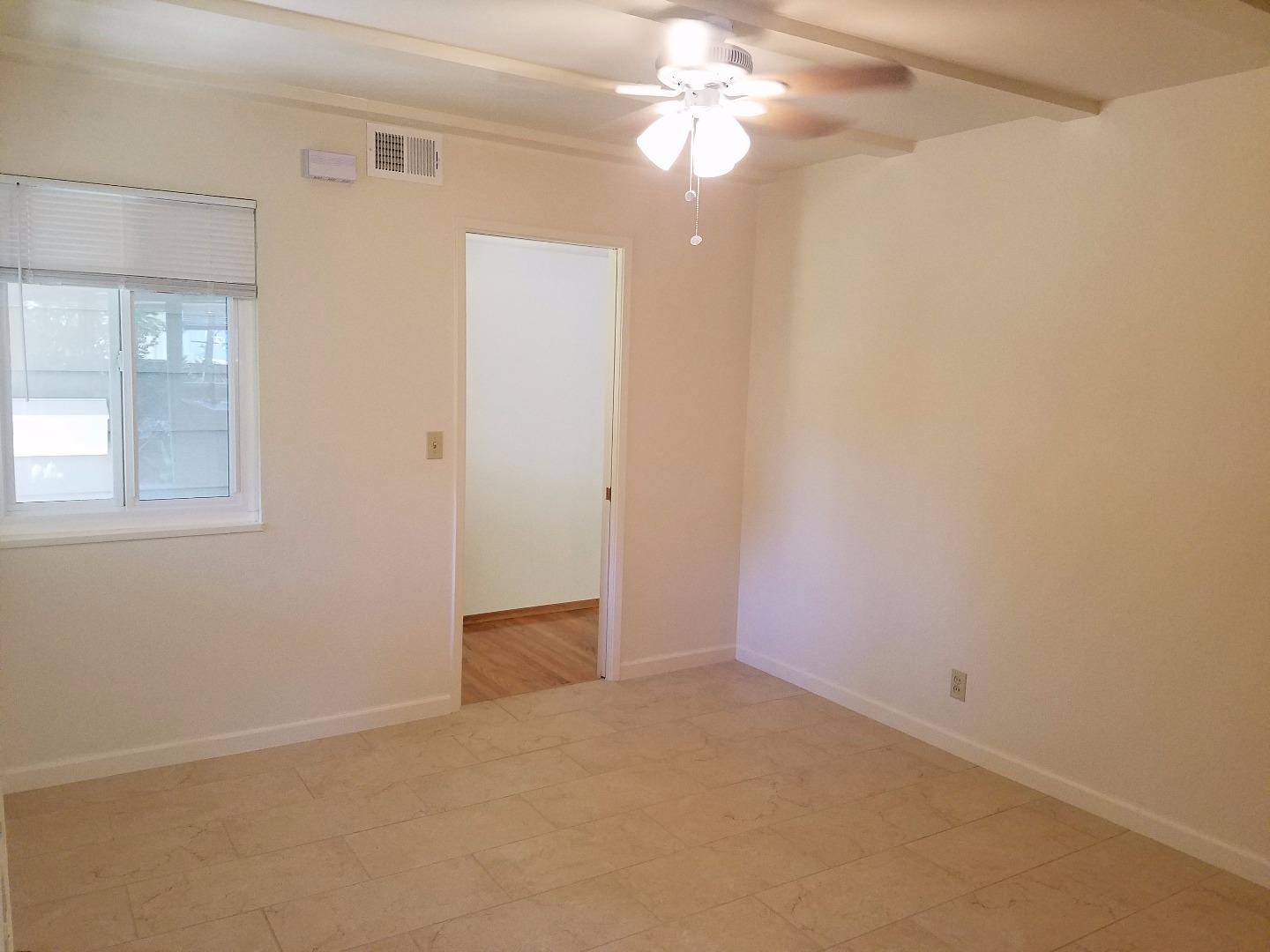 1451 Lewiston Drive Sunnyvale, CA 94087 - Photo 10 of 15 an empty room with a chandelier fan and windows