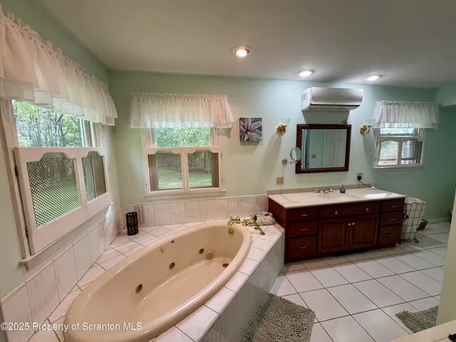 a bathroom with a tub sink and mirror