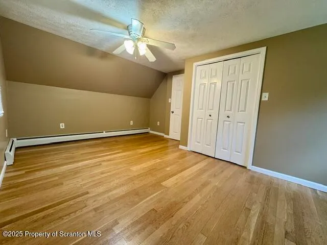 en empty room with wooden floor and fan