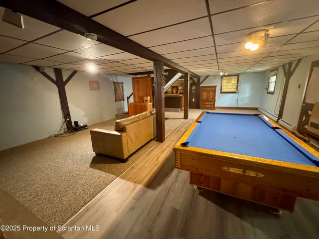 a room with pool table and wooden floor