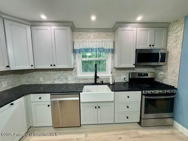 a kitchen with white cabinets and appliances