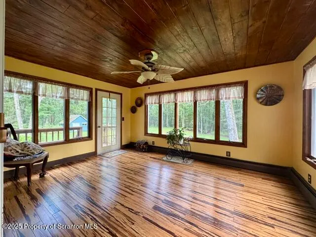 a view of room with wooden floor and furniture