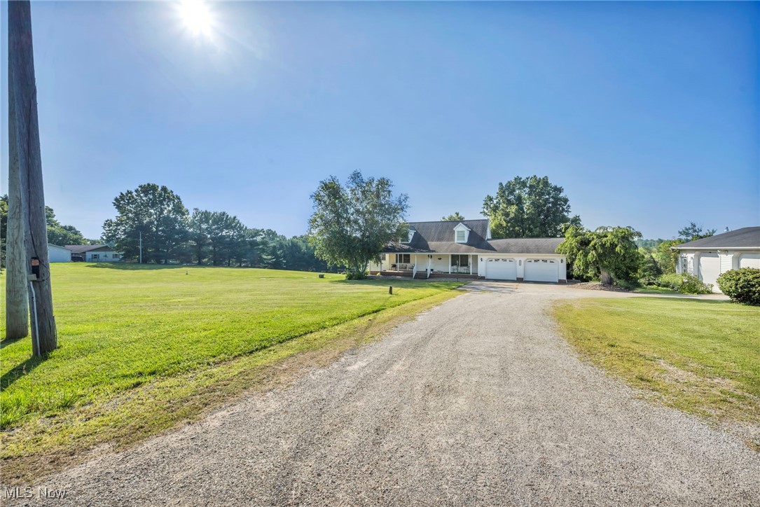 View of front of property with driveway, an attached garage, and a front lawn