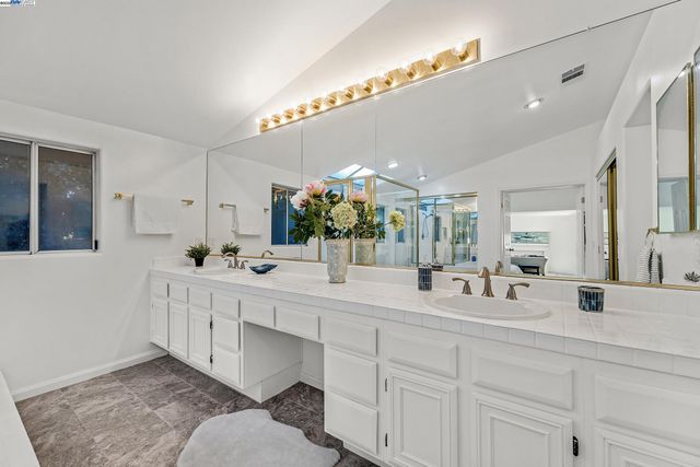 a bathroom with double vanity sink and a mirror