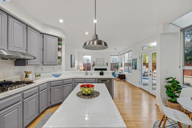 a kitchen with stainless steel appliances granite countertop a sink a stove and a wooden floors